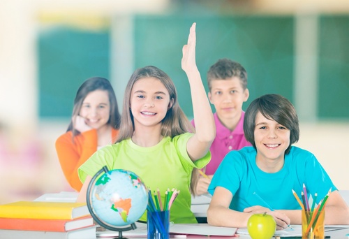 Students raise their hands in class Stock Photo