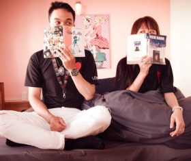 Take book covering her face Young couple Stock Photo