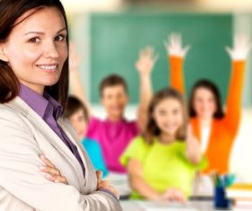 Teachers and students raising their hands in class Stock Photo