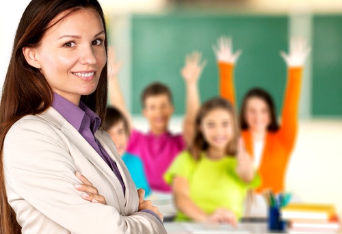 Teachers and students raising their hands in class Stock Photo