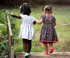 Two little girls hand in hand over wooden bridge Stock Photo