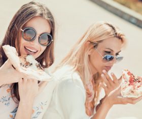 Two woman eating pizza Stock Photo 01