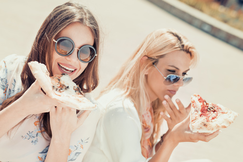 Two woman eating pizza Stock Photo 01