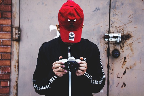 Wearing a red hat holding a camera Stock Photo