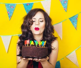 Woman blowing birthday candles Stock Photo