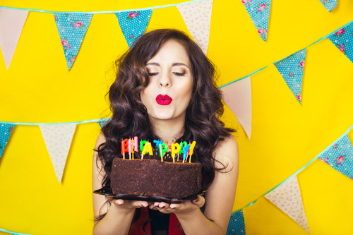 Woman blowing birthday candles Stock Photo