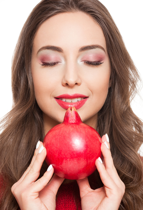 Woman red eye shadow and pomegranate