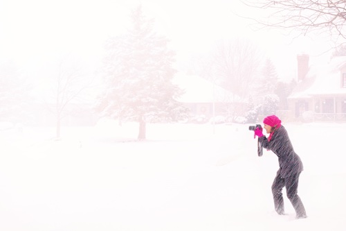 Woman shooting snow scene with camera Stock Photo