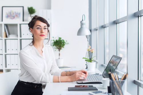 Woman sitting in the office looking out the window Stock Photo