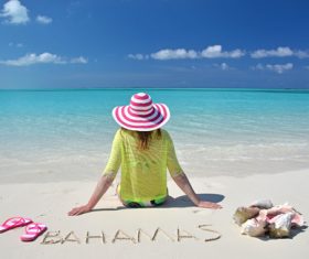 Woman sitting on the beach of Bahamas Stock Photo