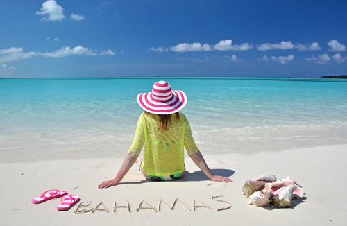 Woman sitting on the beach of Bahamas Stock Photo