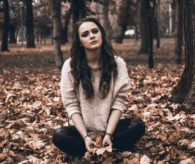 Woman sitting on the floor holding leaves Stock Photo