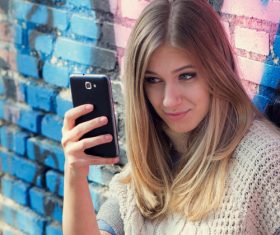 Woman sitting on the floor taking a selfie with a mobile phone Stock Photo