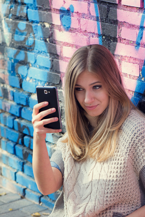 Woman sitting on the floor taking a selfie with a mobile phone Stock Photo