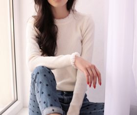 Woman sitting on the window sill Stock Photo