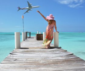 Woman standing on wooden bridge waving Stock Photo