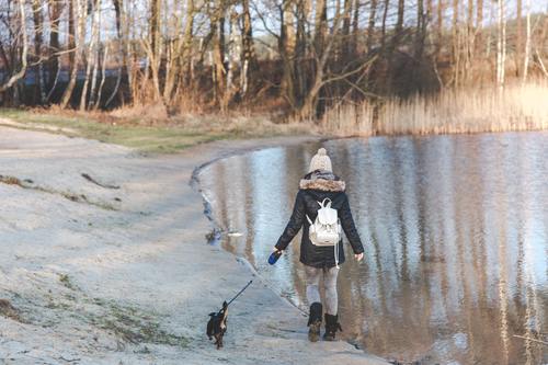 Woman walking the dog by the river Stock Photo