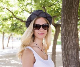 Woman wearing hat and sunglasses in the park Stock Photo