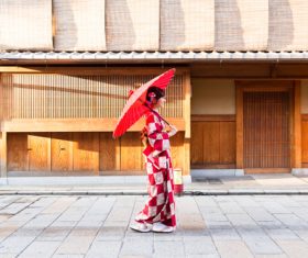 Woman wearing japanese national costume walking on the road Stock Photo