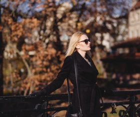 Woman wearing sunglasses standing on the bridge in autumn Stock Photo