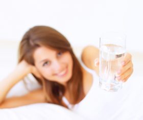 Young girl drinking water in bed Stock Photo 02