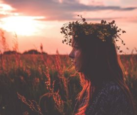 Young girl with flowers wreath at sunset Stock Photo