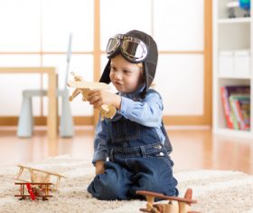 a child playing with a wooden plane Stock Photo 01