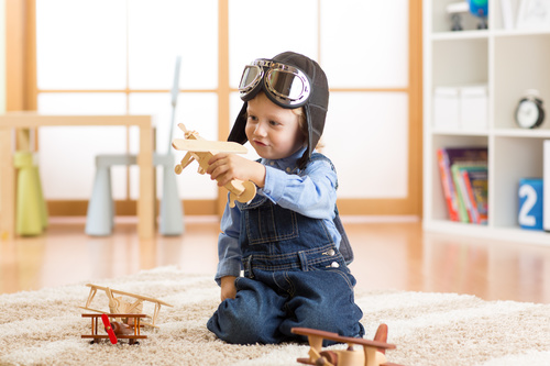 a child playing with a wooden plane Stock Photo 01