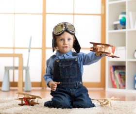 a child playing with a wooden plane Stock Photo 02