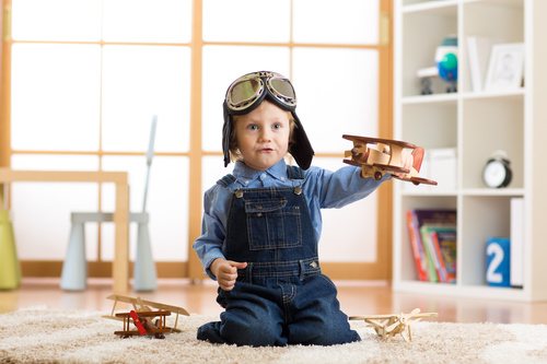 a child playing with a wooden plane Stock Photo 02