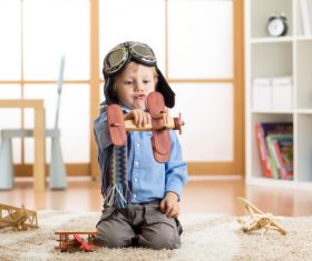 a child playing with a wooden plane Stock Photo 03