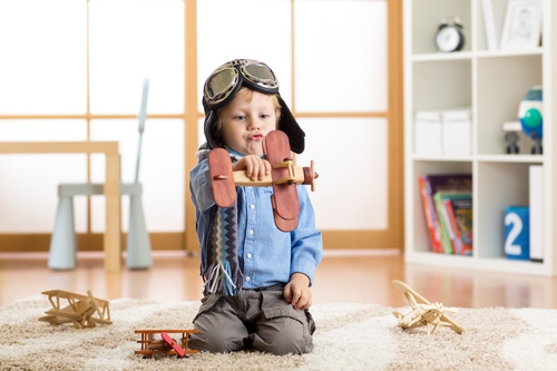 a child playing with a wooden plane Stock Photo 03