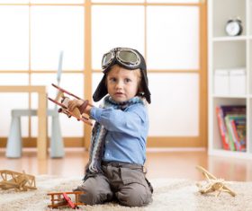 a child playing with a wooden plane Stock Photo 04