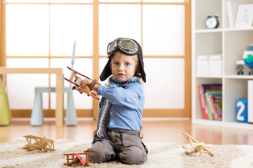 a child playing with a wooden plane Stock Photo 04
