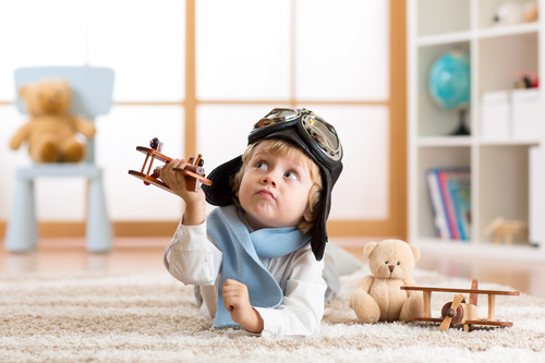 a child playing with a wooden plane Stock Photo 05