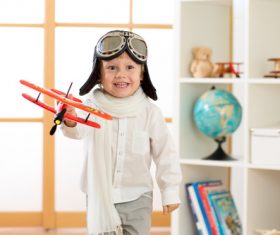 a child playing with a wooden plane Stock Photo 06
