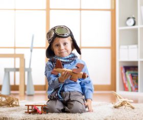 a child playing with a wooden plane Stock Photo 07