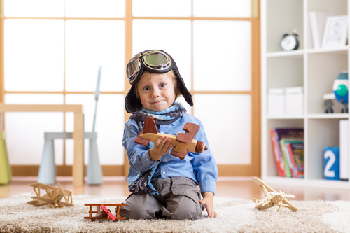 a child playing with a wooden plane Stock Photo 07