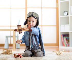 a child playing with a wooden plane Stock Photo 09