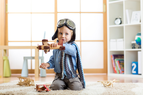 a child playing with a wooden plane Stock Photo 09