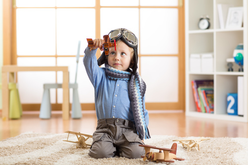 a child playing with a wooden plane Stock Photo 13