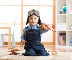 child playing with toy airplane at home Stock Photo 01