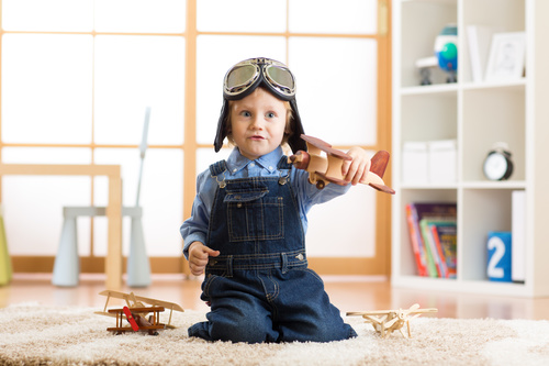 child playing with toy airplane at home Stock Photo 01
