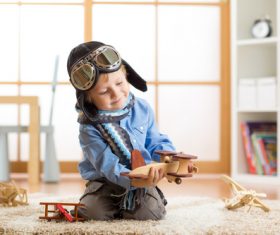 child playing with toy airplane at home Stock Photo 02