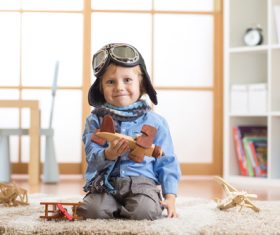 child playing with toy airplane at home Stock Photo 03