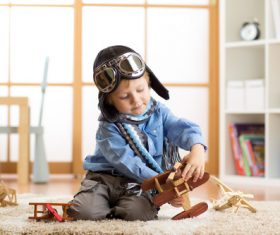 child playing with toy airplane at home Stock Photo 04