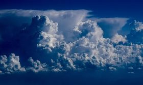 Airplane photographing cumulus clouds in the sky Stock Photo