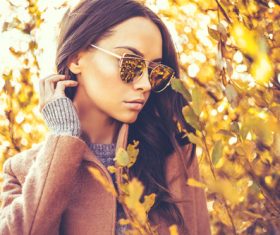 Autumn woman wearing sunglasses looking at the withered tree Stock Photo
