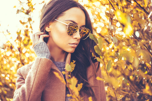 Autumn woman wearing sunglasses looking at the withered tree Stock Photo
