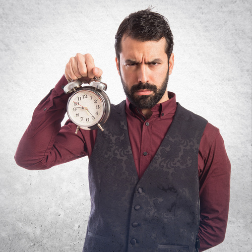 Bearded Man holding an alarm clock Stock Photo